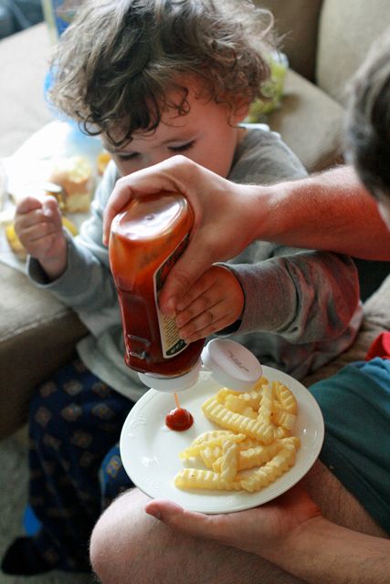 toddler making fries - 9 squeezing ketchup on plate