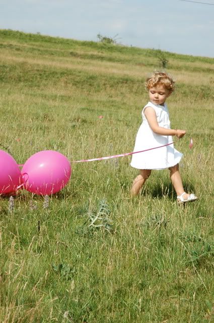 little girl in dress with pink balloons