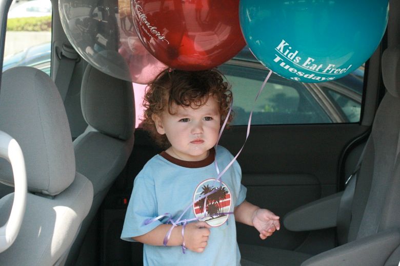 boy with balloons in minivan