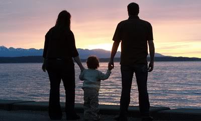 family silhouetted on beach at sunset