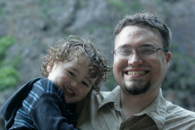 father and son playing at the waterfall