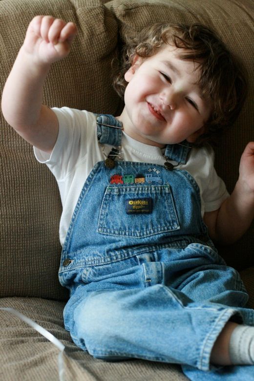 Mikko doing a silly smile in train overalls m3yo