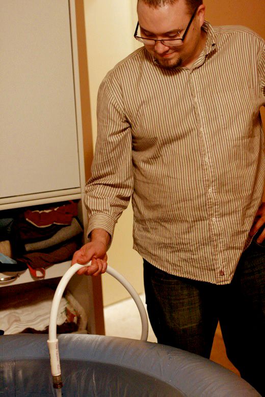 Alrik's birth story: Sweet surprise unassisted home water birth = Hobo Mama homebirth — husband filling birthing tub