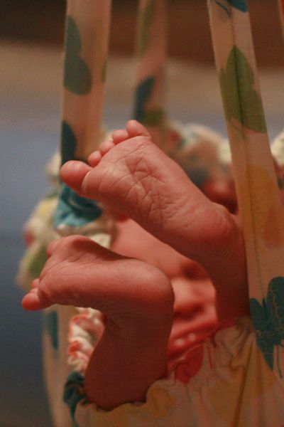 midwives weighing newborn baby at home birth on midwife scale — homebirth
