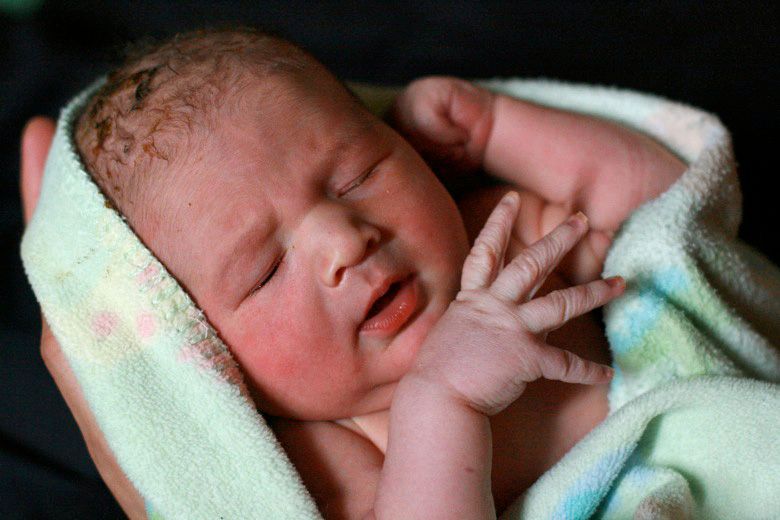 Alrik's birth story: Sweet surprise unassisted home water birth = Hobo Mama homebirth — newborn baby in blanket