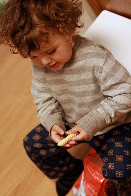 toddler making fries - 3 holding frozen fry