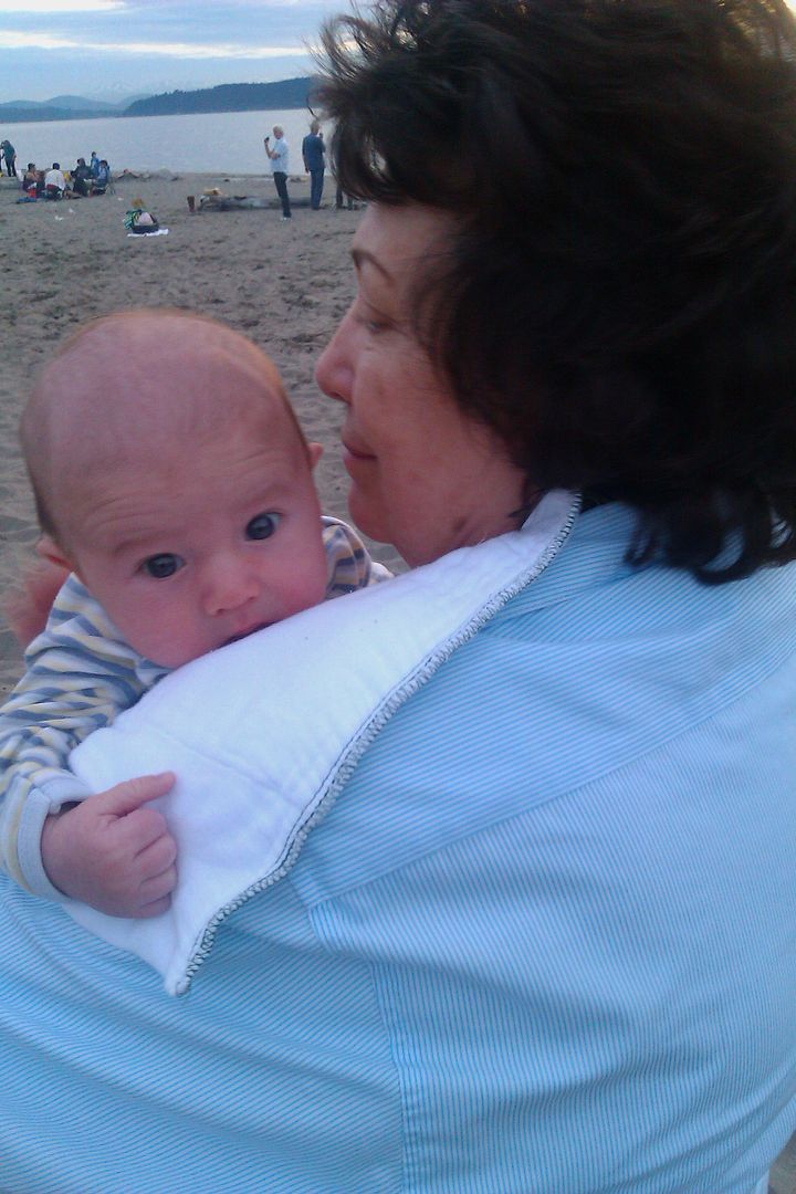 newborn baby with grandmother on the beach