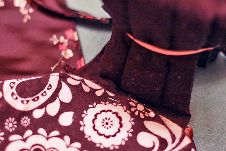 Photo Credit: Hobo Mama pinning around straps — black mei tai tutorial