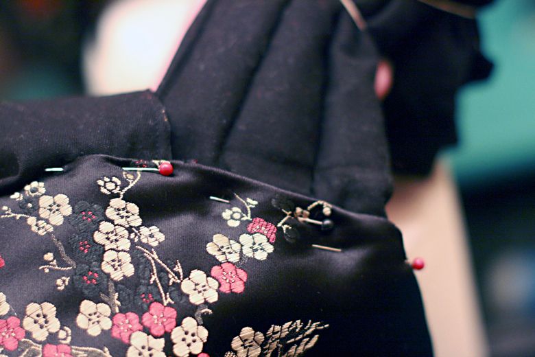 Photo Credit: Hobo Mama pinning around straps — black mei tai tutorial