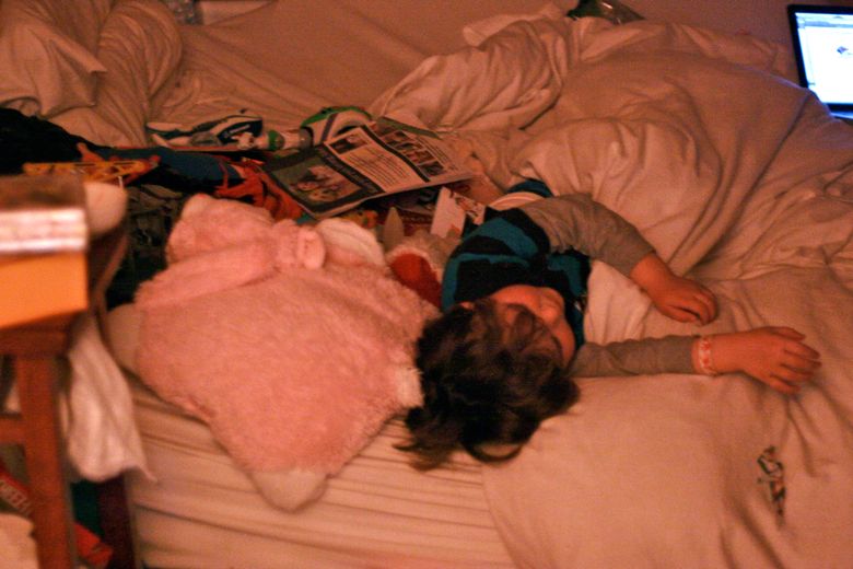 Photo Credit: Hobo Mama boy sleeping on bed with toys piled next to him