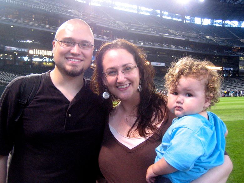 family of dad, mom, and baby at Safeco Field for baseball game