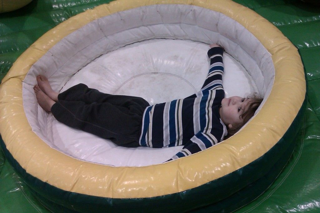 Sunday Surf: Demand photos == Hobo Mama boy with arms outspread on floor of bouncy castle