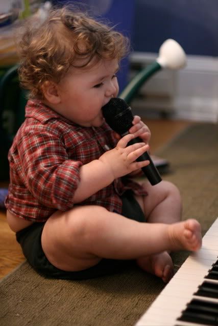 baby singing into microphone and playing keyboard