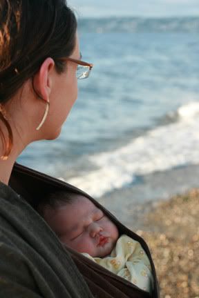 wearing newborn baby in wrap on beach