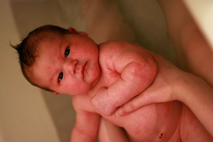 Newborn baby in the big bathtub with mama