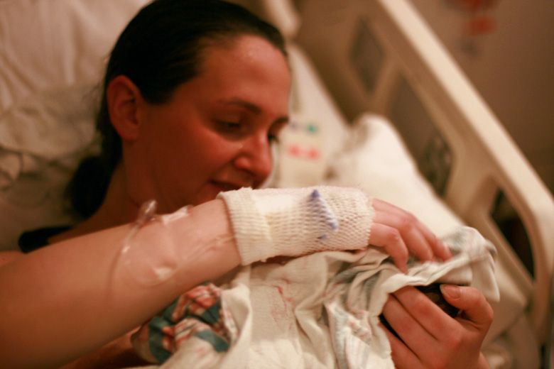 mother's first look at newborn in hospital bed