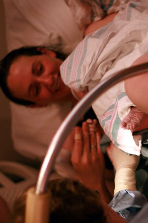 birth — tiny newborn foot family in hospital bed