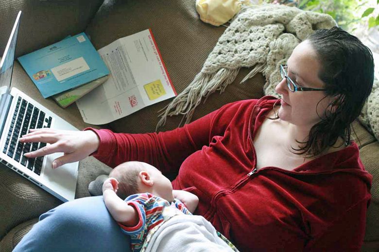 blogging mother trying to type one-handed on computer over newborn baby alrik anb