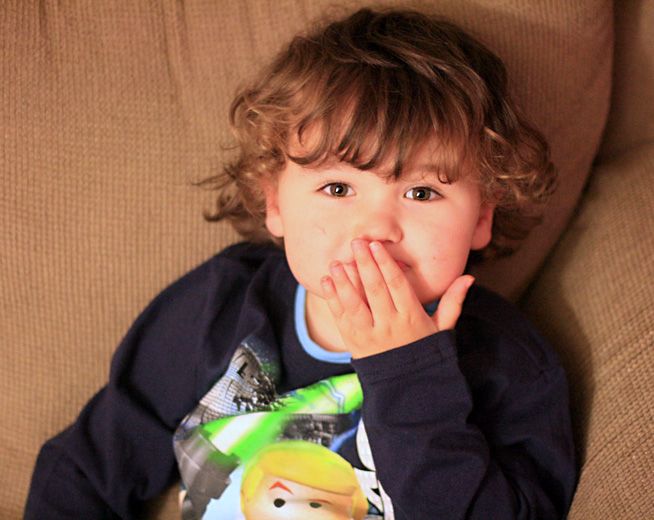 boy with hand over his mouth