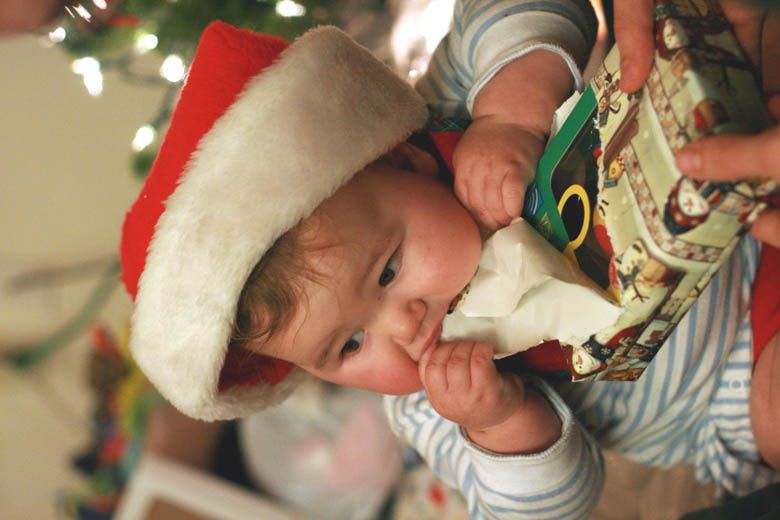 Photo Credit: Hobo Mama baby in Santa hat eating wrapping paper