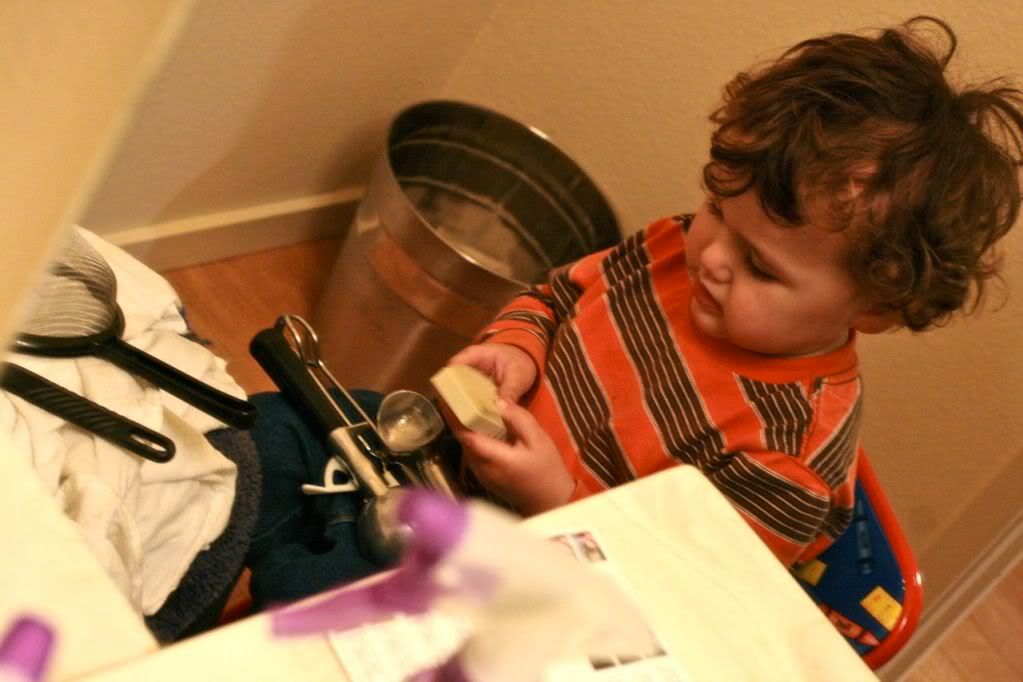 toddler playing in bathroom with kitchen implements