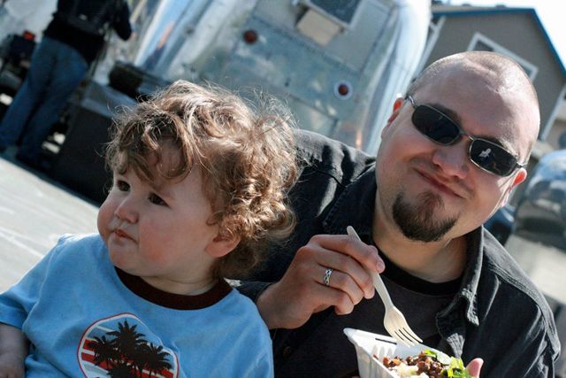 father and son eat poutine from skillet