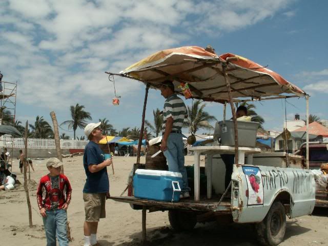 Doug and Andrew talk with a man selling coconuts.