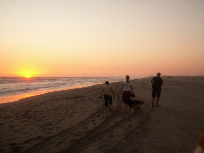 Sarah, Basilia and Esteban walking on the beach with Mindy, Sarah's dog